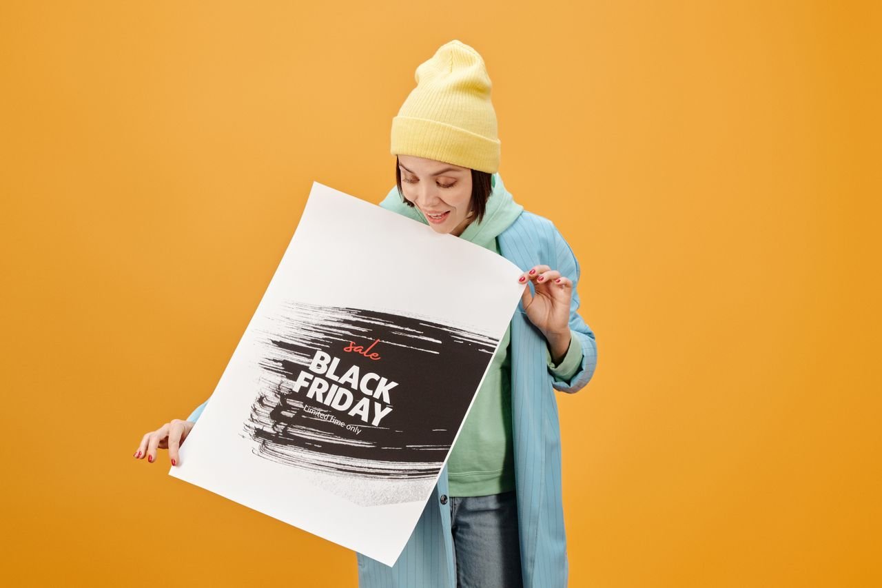 Woman in casual wear with a Black Friday sale poster on a yellow background.