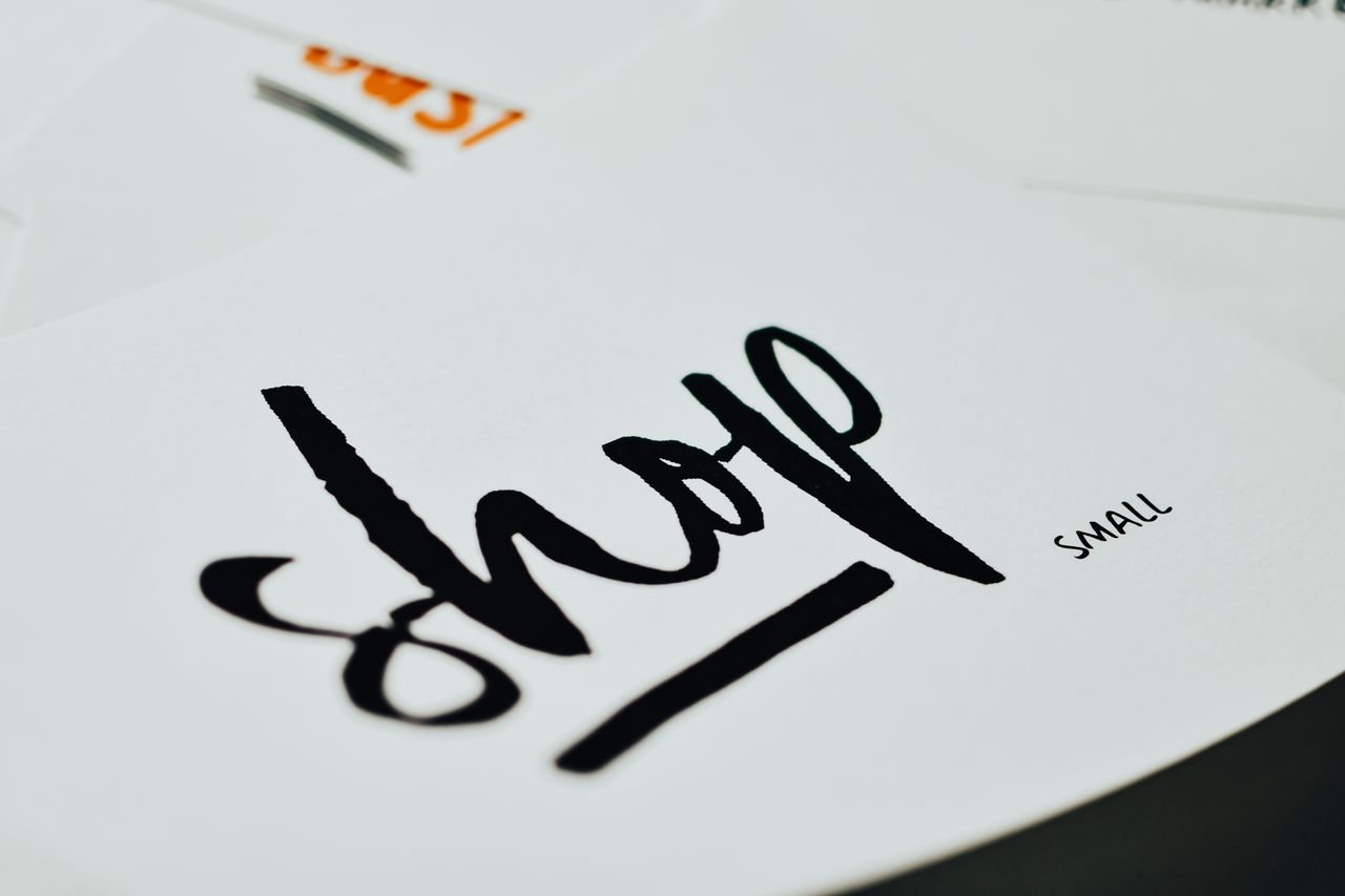 services-04 Close-up of "shop small" handwritten on white paper. Ideal for small business or shop promotions.